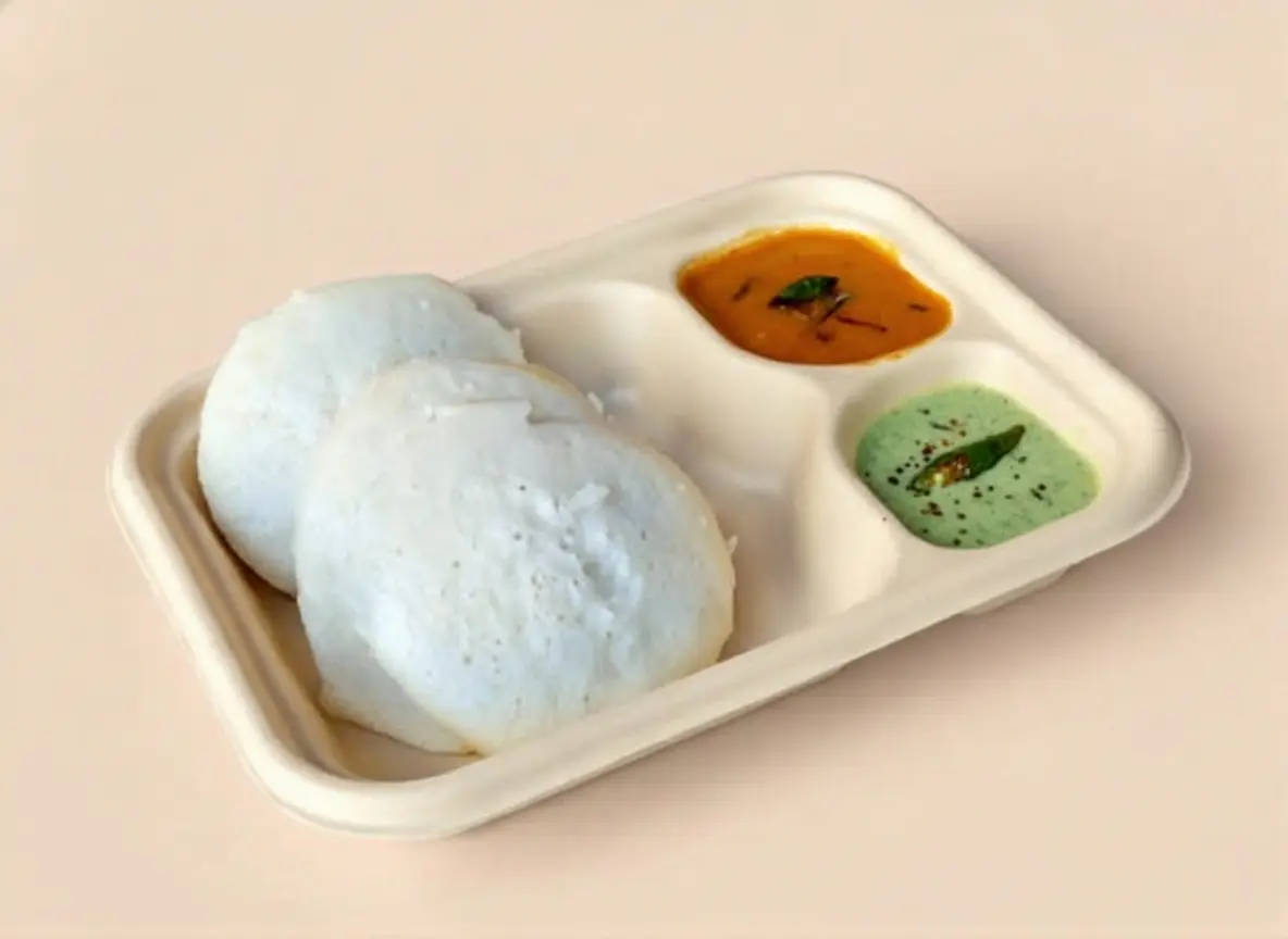 Soft, steamed rice cakes served in pairs, a traditional South Indian breakfast staple.